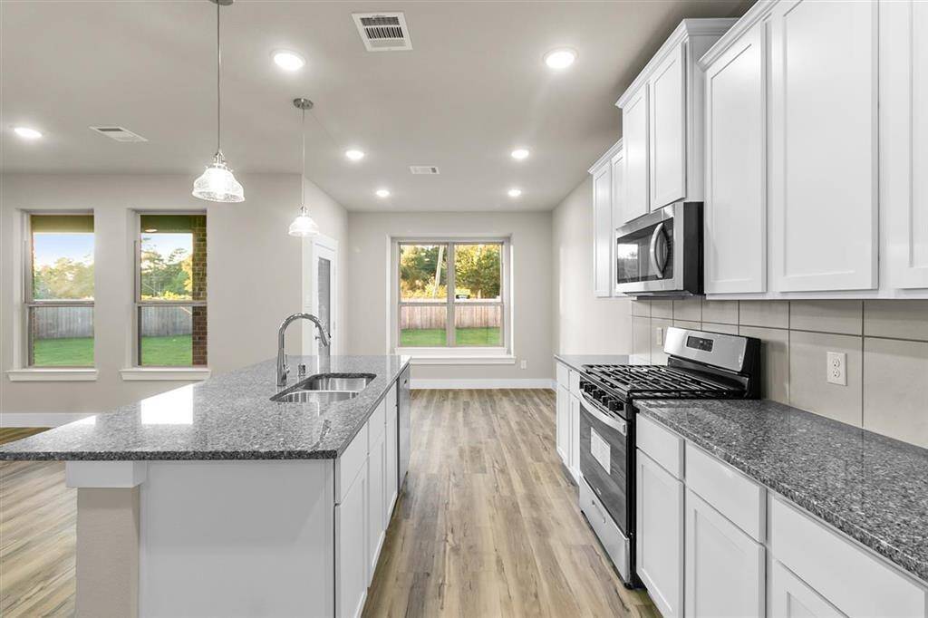 The sleek countertops, with their soft veining, invite you to gather around, whether for a quick breakfast or a weekend feast with friends.