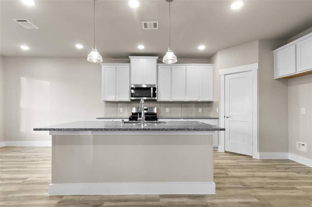 The sleek countertops, with their soft veining, invite you to gather around, whether for a quick breakfast or a weekend feast with friends.