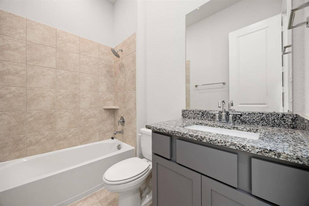 Secondary bathroom features light countertops and cabinets, custom paint, shower/tub combo with tile surround, large mirror, tile floors, sleek fixtures and modern finishes, plenty of space to accommodate any visiting family or guests. *Virtually Staged