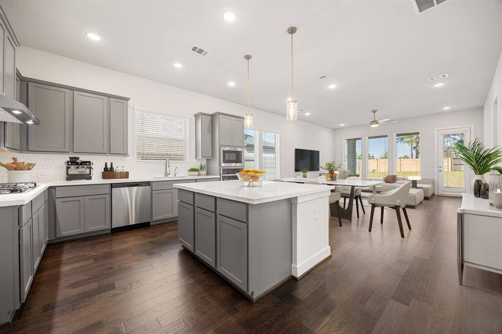 This kitchen is by far any chef’s dream! This spacious kitchen features large windows, high ceilings, dark stained wood cabinets, granite countertops, SS appliances, modern tile backsplash, recessed lighting with additional custom pendant lighting, granite kitchen island, and a walk-in pantry all overlooking your huge family room. *Virtually Staged