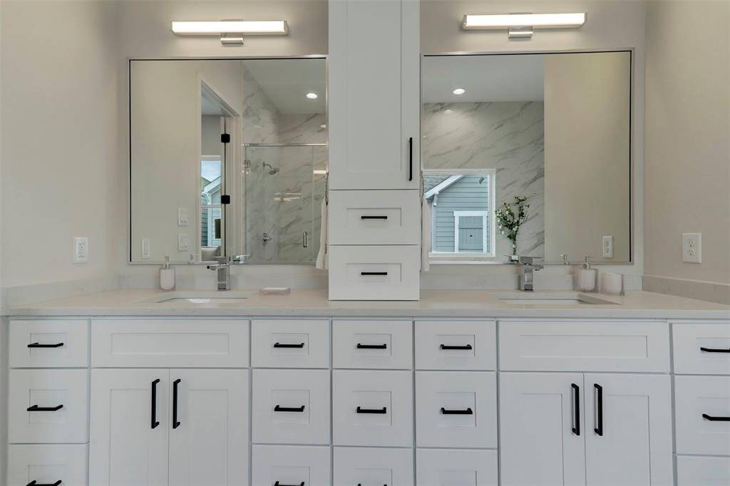 Primary en-suite bathroom w/ double vanity and ample storage