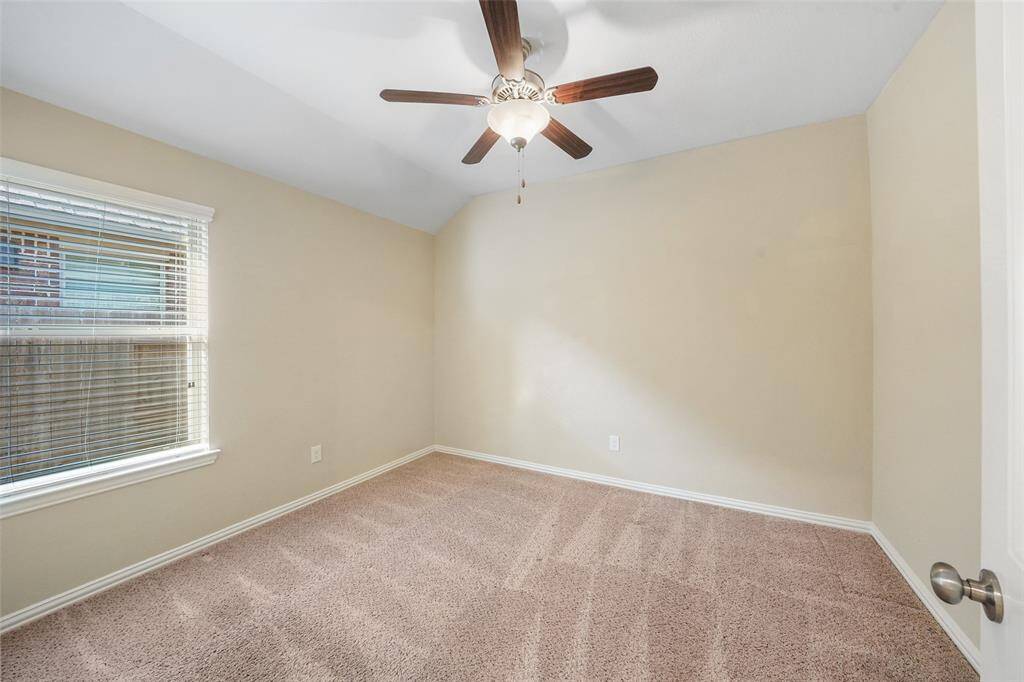 Secondary bedroom with neutral paint, and ceiling fan.