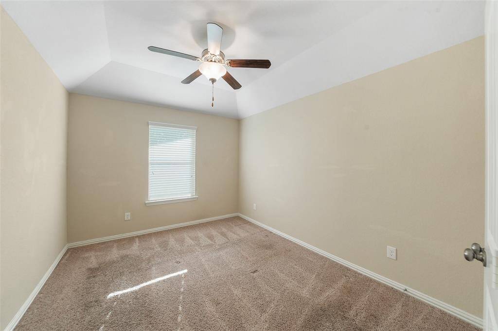 Secondary bedroom with neutral paint, and ceiling fan.
