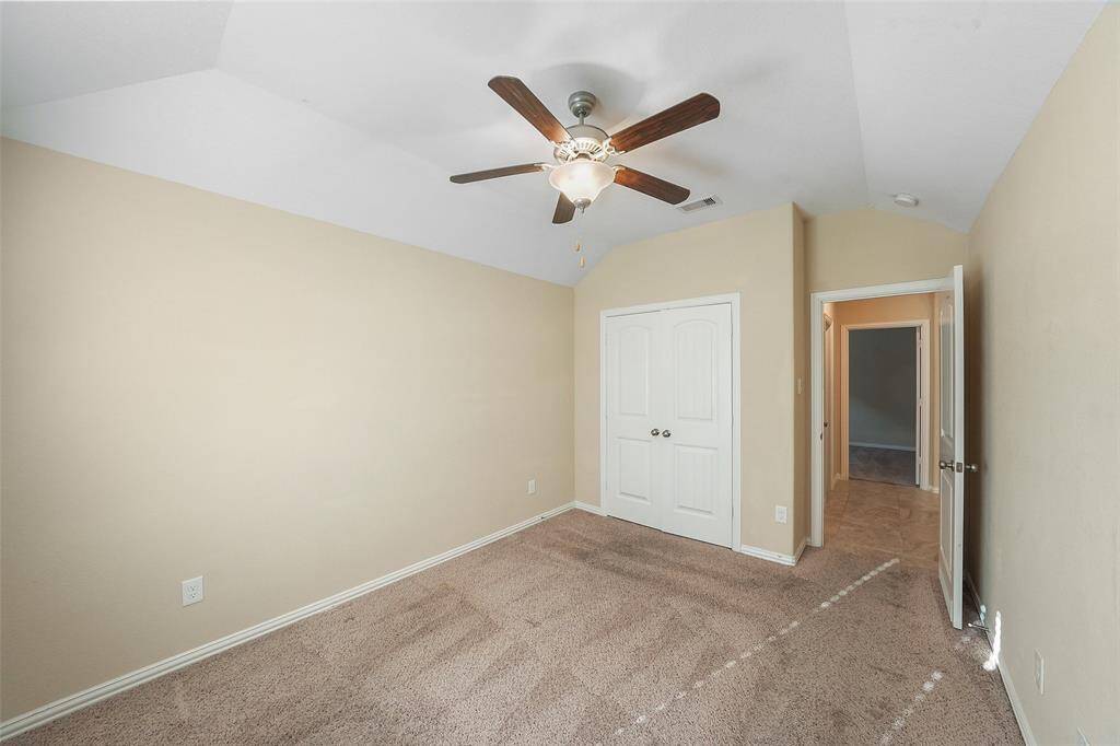 Secondary bedroom with neutral paint, and ceiling fan.