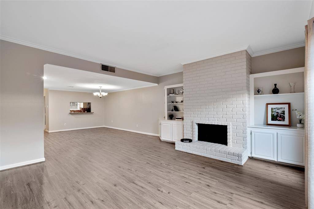 living area with updated flooring and fireplace. notice built ins