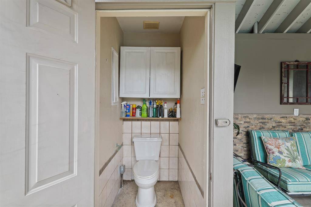 Outdoor toilet adjacent to pool and patio