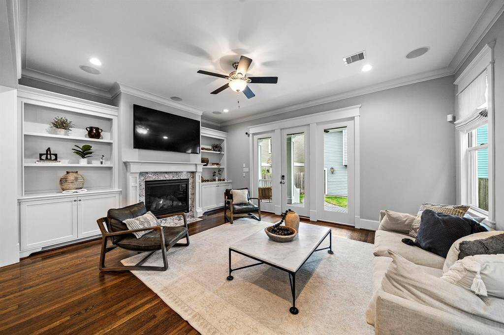 The living room boasts hardwood floors, built-in shelves, cabinets, and a gorgeous gaslog fireplace—perfect for cozy nights and stylish living.