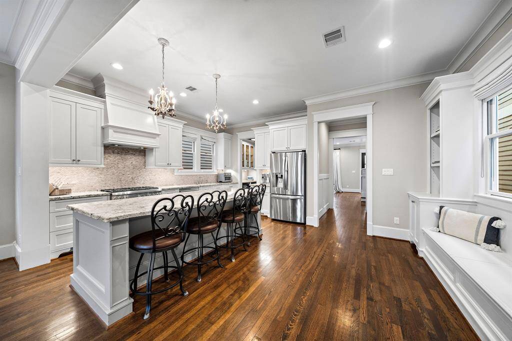 First-floor living makes hosting effortless. The stunning open kitchen, with custom cabinets and built-ins, is the heart of the home—perfect for entertaining!