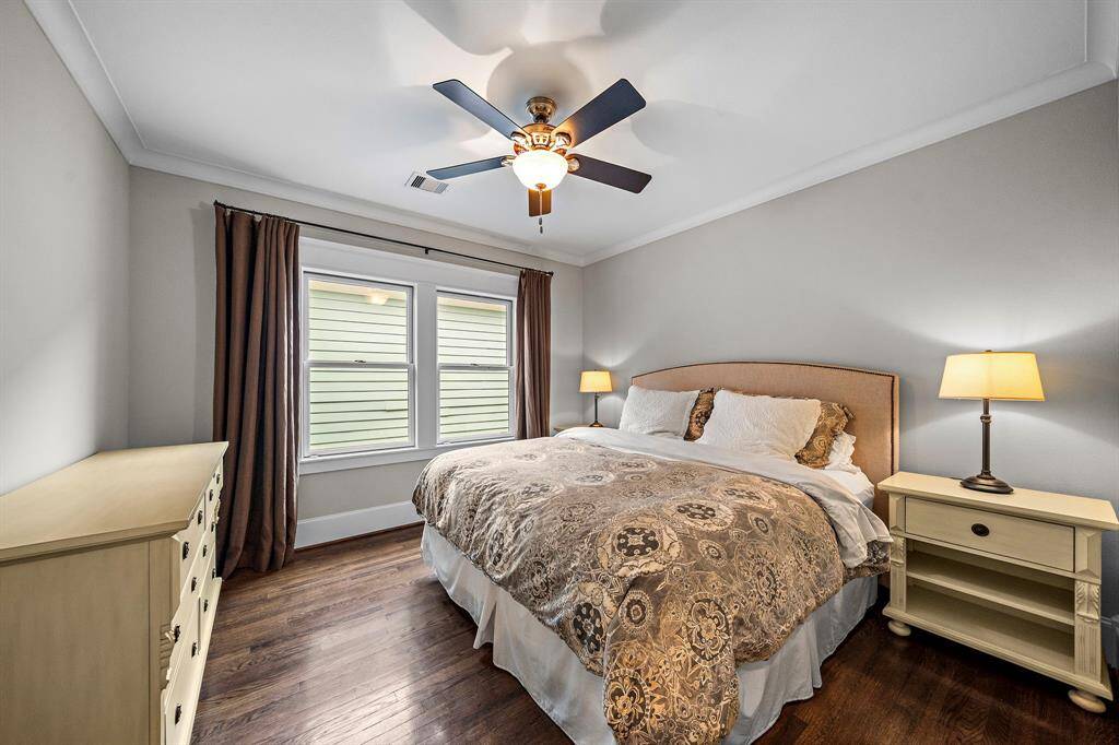 Second bedroom located on the second floor with hardwood floors, crown molding, ceiling fan, and closet.
