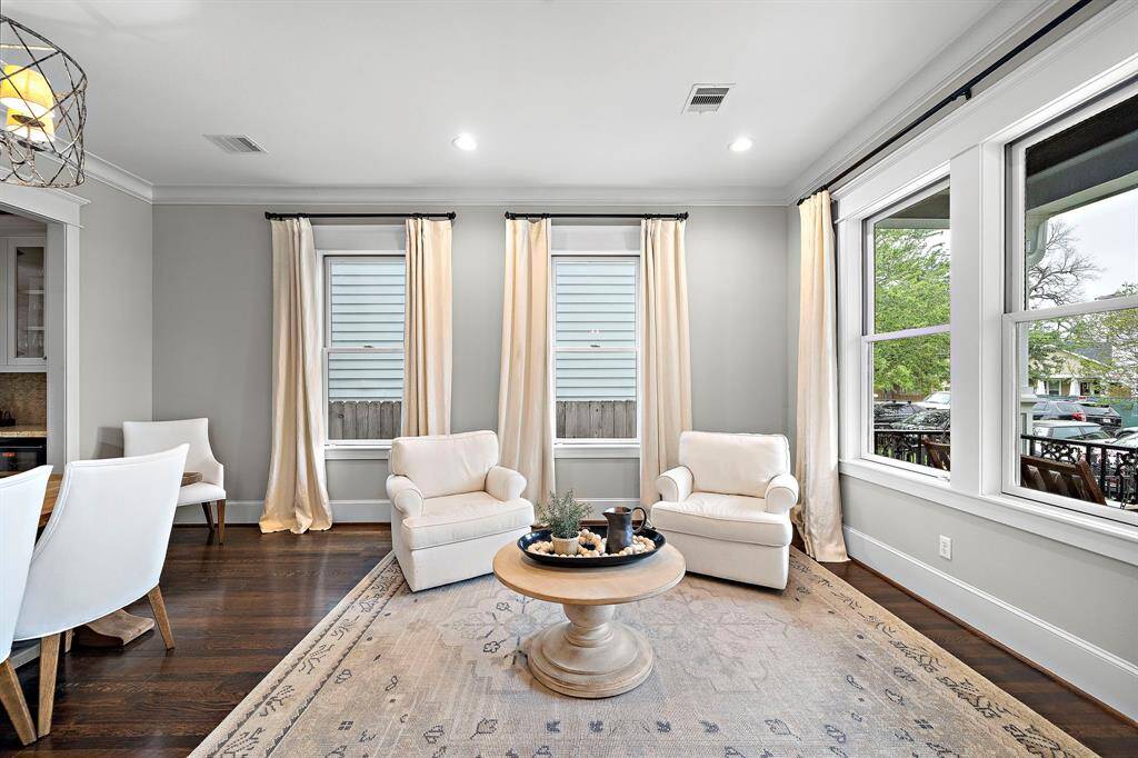 Step inside to a bright and inviting formal living and dining room, bathed in natural light and featuring custom curtains for the perfect ambiance.