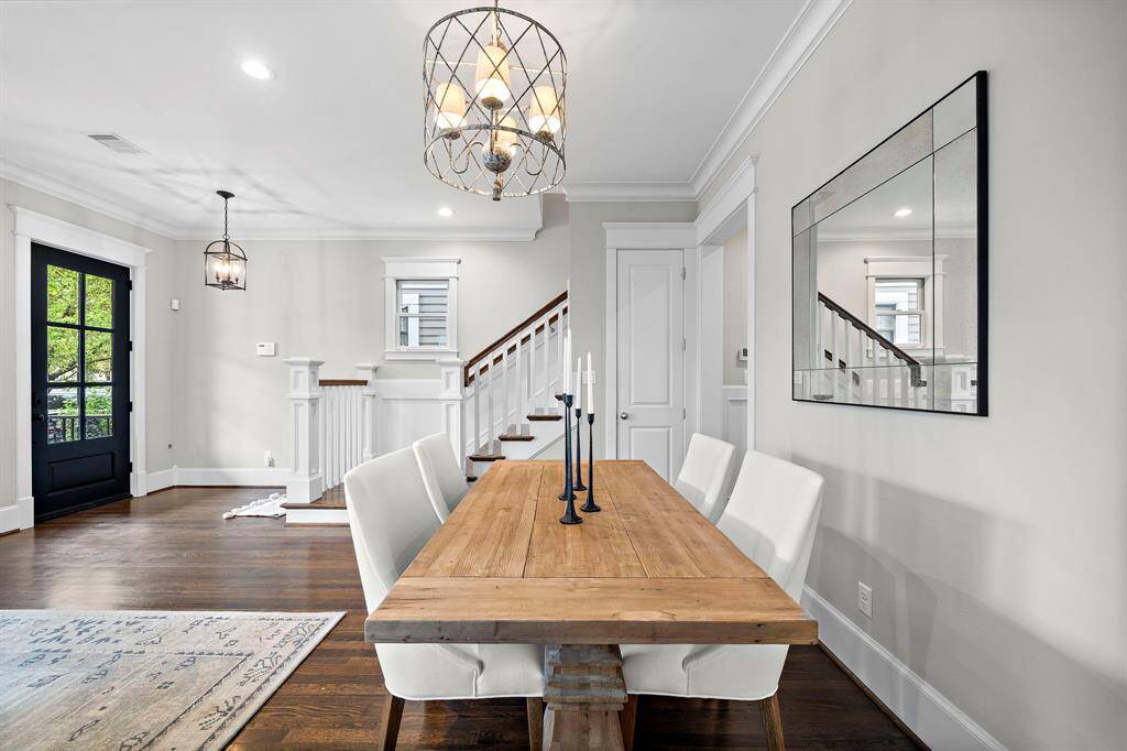 The formal dining room offers a beautiful view, with the front door to the left and a graceful stairway leading to the second floor.
