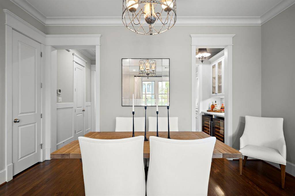 The formal dining room features elegant crown molding, hardwood floors, and easy access to the bar on the right and kitchen on the left. The half bath is just beyond the second door to the left.The formal dining room features elegant crown molding, hardwood floors, and easy access to the bar on the right and kitchen on the left. The half bath is just beyond the second door to the left.The formal dining room features elegant crown molding, hardwood floors, and easy access to