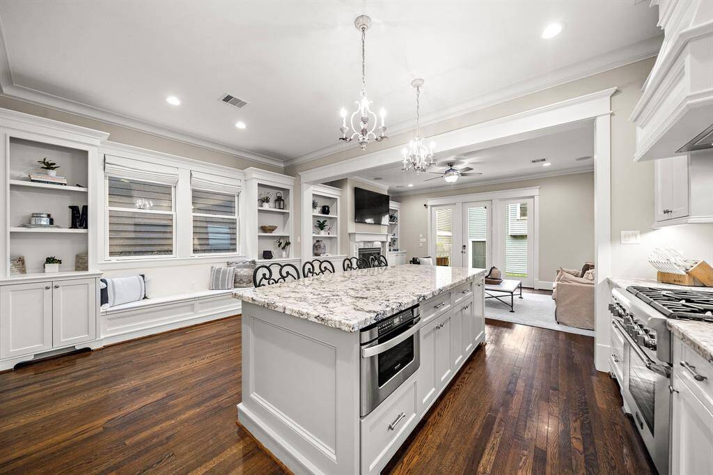 The kitchen is where memories are made, featuring stainless steel appliances, extra built-in cabinets, a bench for seating, and a view of the living room—perfect for entertaining!