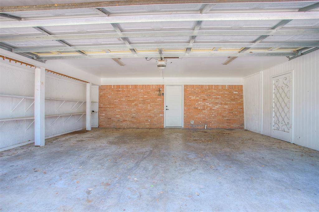 Large garage with shelving and storage room.