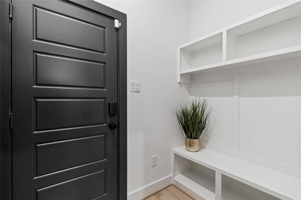 This view highlights the mudroom entrance and the thoughtfully designed area next to the garage door. Featuring a built-in bench, it’s the perfect spot for organizing shoes, bags, and coats, combining functionality with convenience.