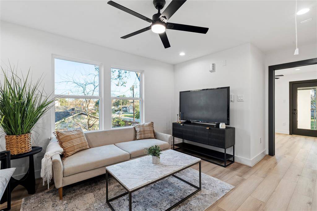 The secondary living space upstairs is bathed in natural light from the large windows, creating a warm and inviting atmosphere. The ample wall space provides endless opportunities for decor or entertainment setups, making this area both functional and versatile.