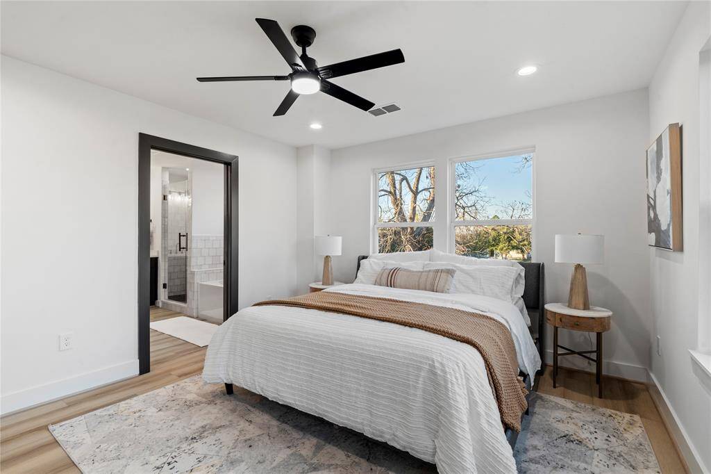 The primary bedroom's generous size and abundance of natural light are even more apparent. The versatile layout includes a doorway leading into the luxurious primary bath, enhancing the sense of comfort and convenience.