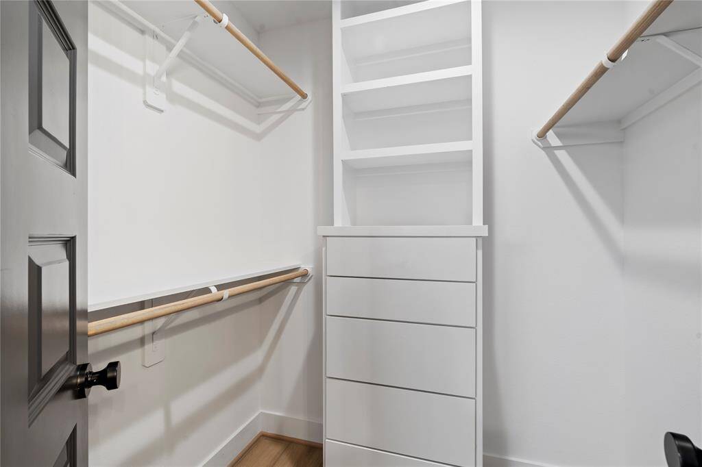 This spacious walk-in closet is designed with built-in storage, offering ample space for organization and easy access to your wardrobe. The thoughtful layout ensures both style and function, making it a perfect addition to your primary suite.