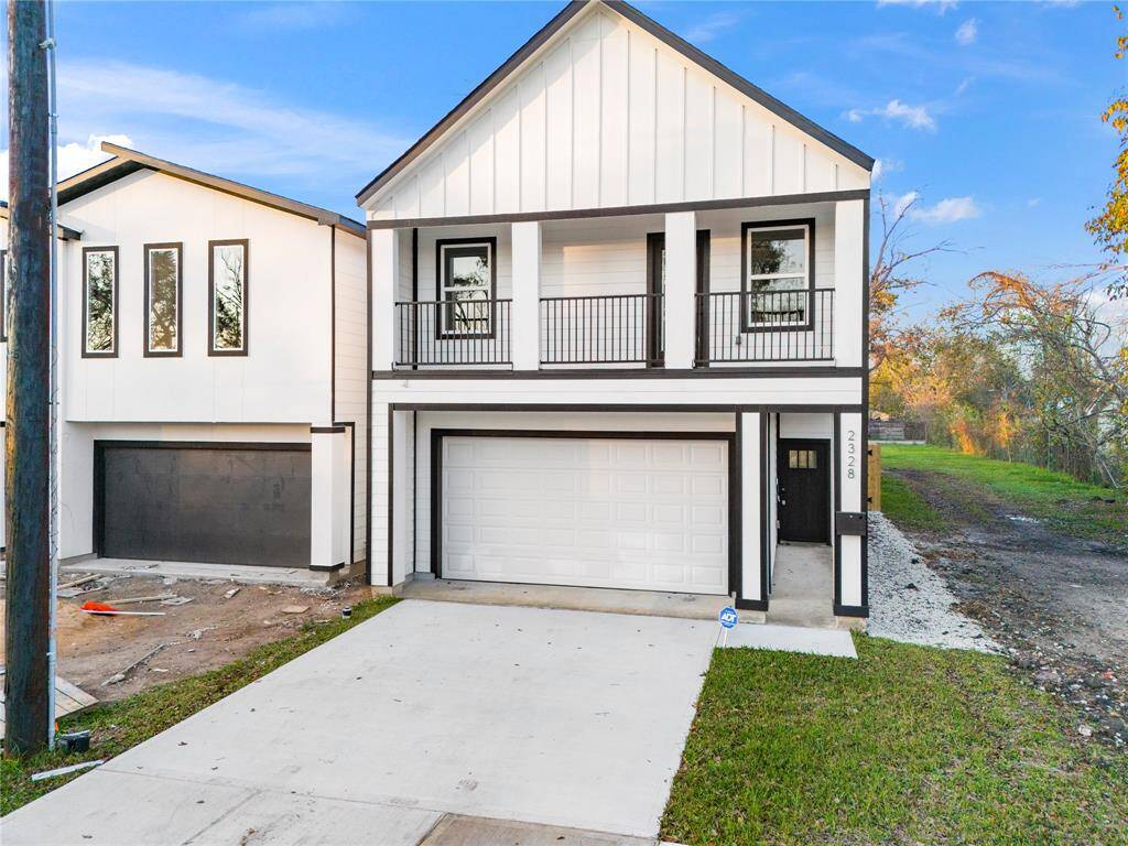 Spacious driveway, inviting balcony, and large windows that let natural light flood in, creating an airy, open atmosphere perfect for living and entertaining