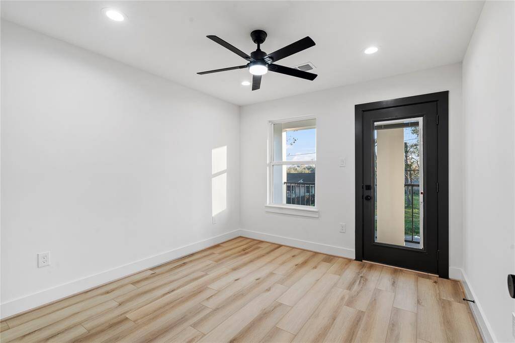 This inviting bedroom is bathed in natural light from a large window and features a door that leads to a private second-floor balcony. It’s the ideal spot to relax and enjoy the fresh air, enhancing the tranquil atmosphere of the room.