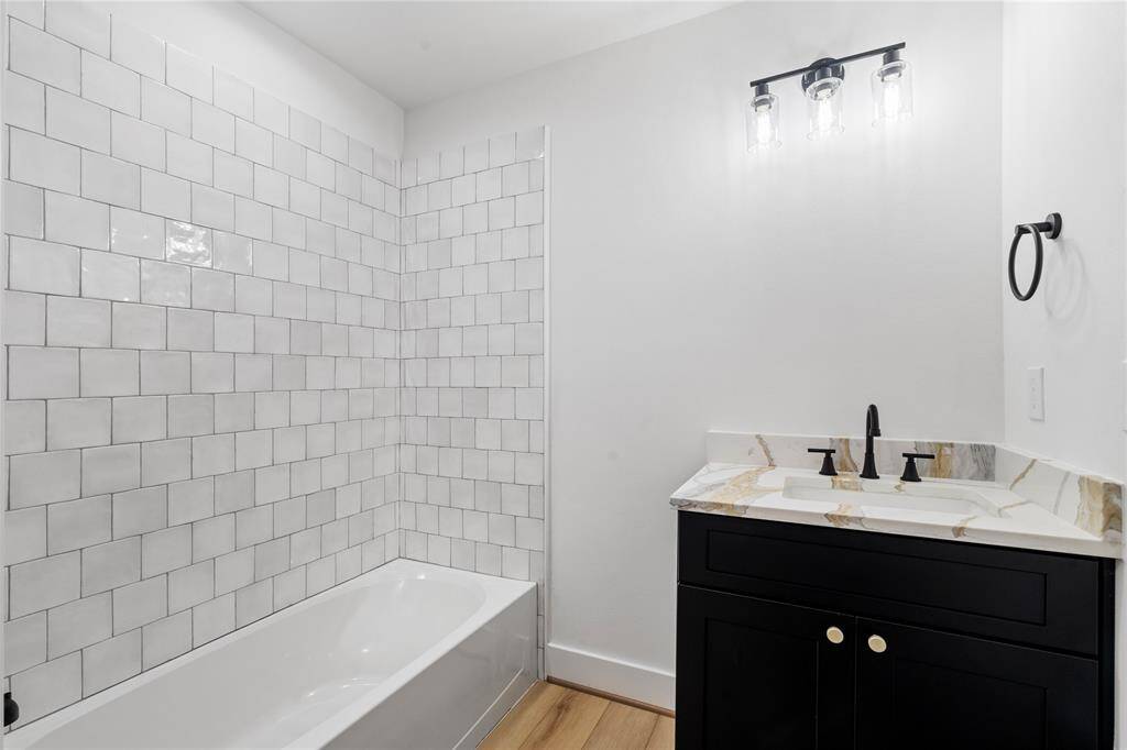 This secondary full bathroom features a shower with a tub, combining practicality with comfort. The contemporary design creates a welcoming, functional space perfect for everyday use.