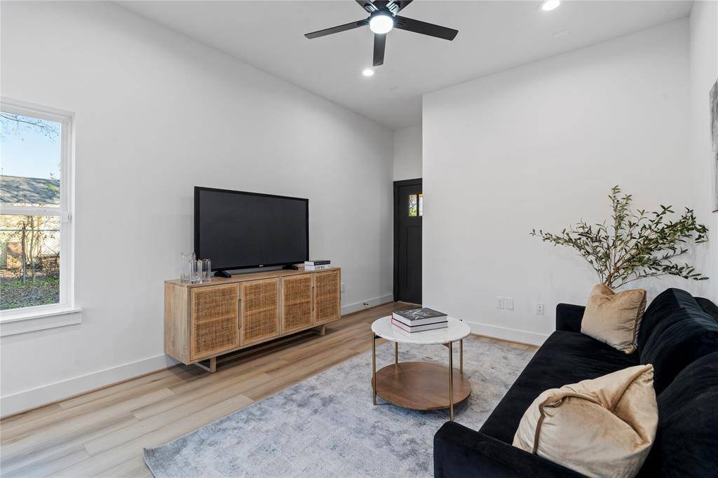 As you continue through the living area, notice the thoughtful layout, with ample wall space for a large TV or artwork. The natural light streaming through the window enhances the room's warm, inviting feel, while the open design makes it ideal for everyday living or hosting guests.