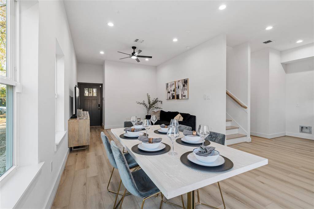 From this angle, you can see how the dining area flows effortlessly into the living space, showcasing the home's open-concept design. Large windows and thoughtful lighting create a bright, cohesive atmosphere.
