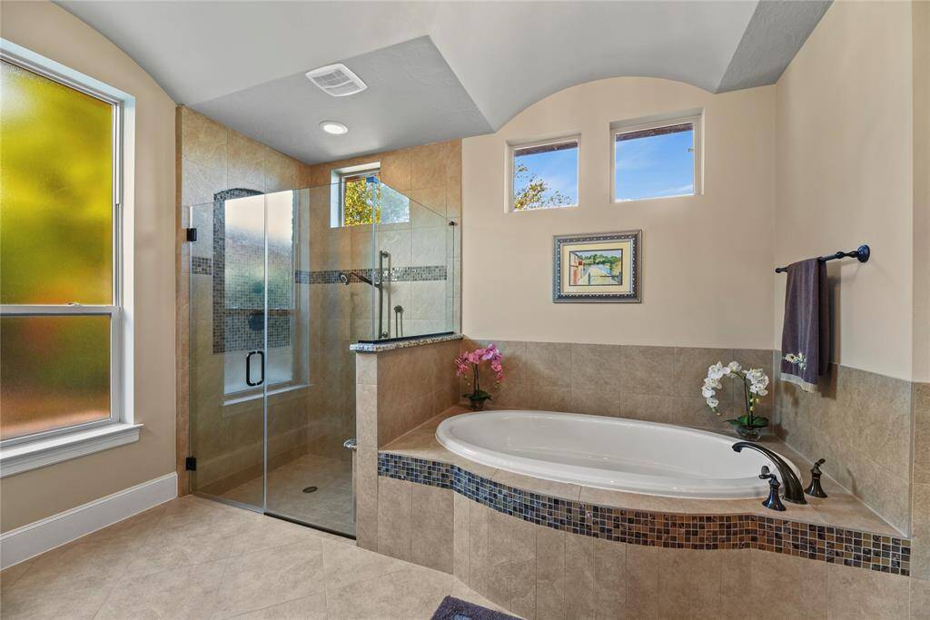 The spa-like primary bathroom includes a large, soaking tub and oversized shower.