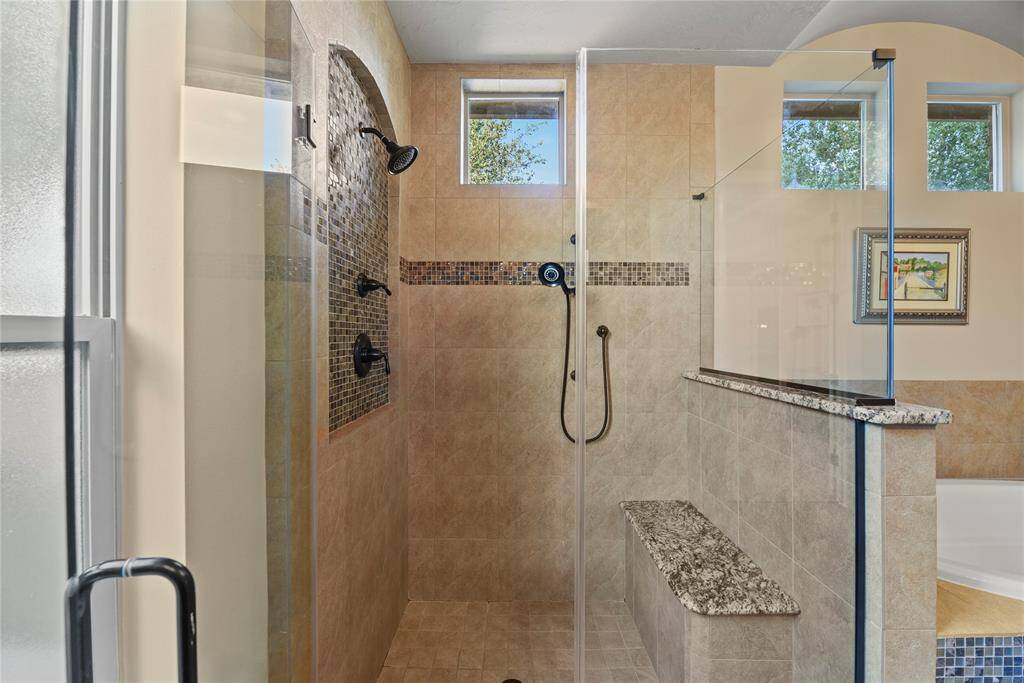 Dual showerheads and a bench in the frameless shower.