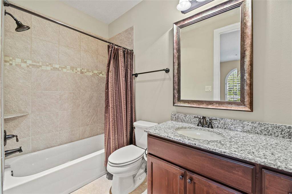 One of two upstairs bathrooms with a granite vanity and tub/shower combination.
