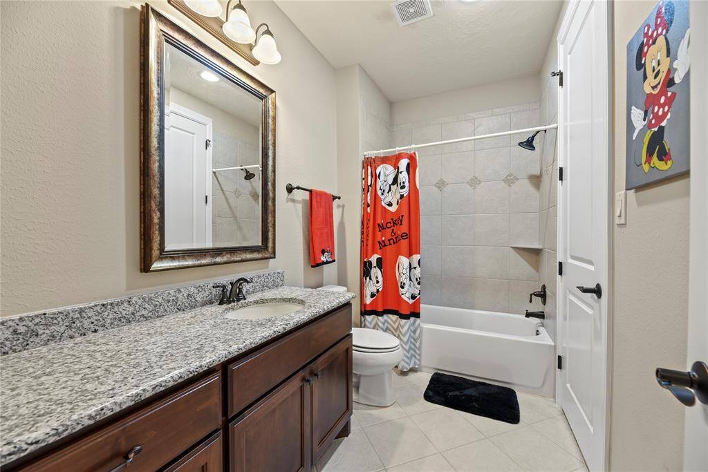 Upstairs bathroom with a large vanity and tub/shower combination.