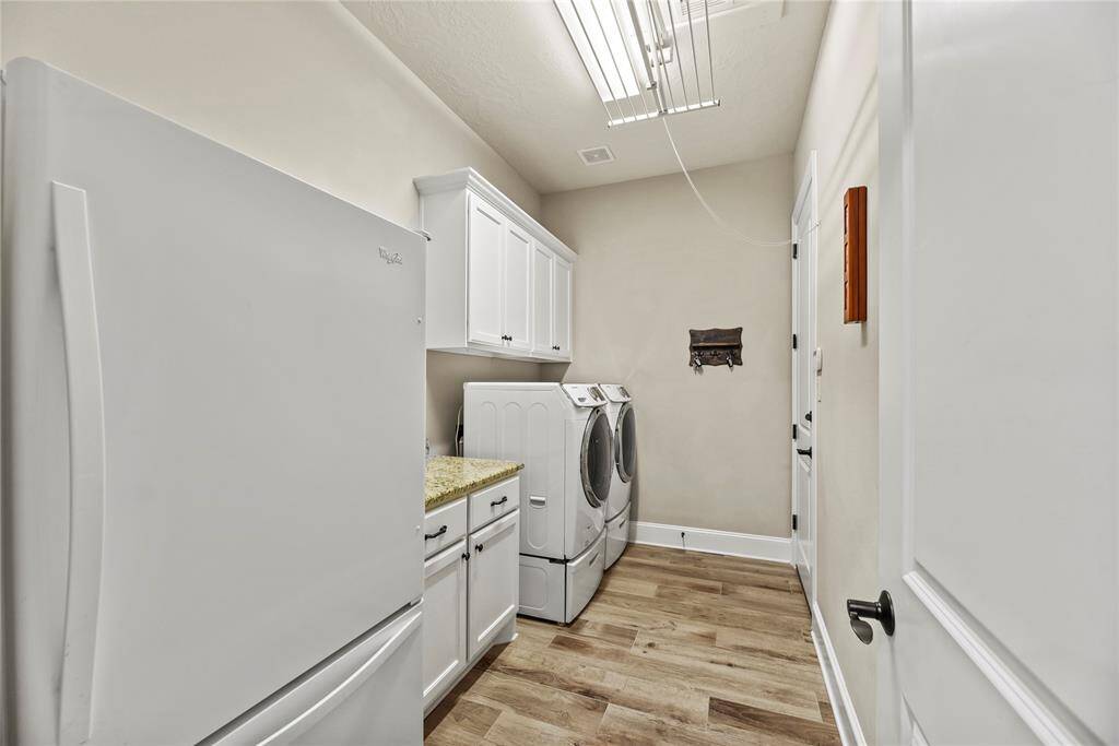 Utility room with storage cabinets and plenty of space for a refrigerator.