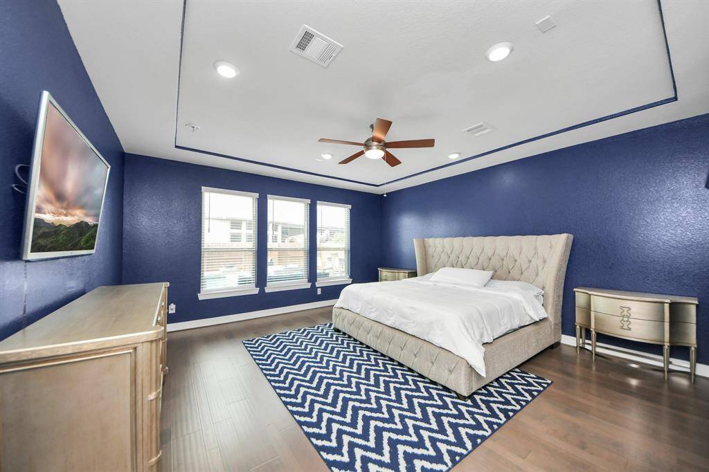 Step into the sanctuary of theprimary bedroom. Featuring beautiful floors, custom paint, recessed lighting, ceiling fan, and large windows.