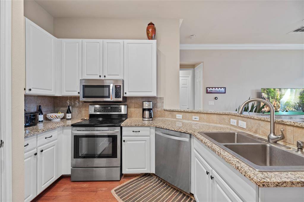 Beautiful granite counters blend perfectly with the crisp white cabinets and wood flooring.
