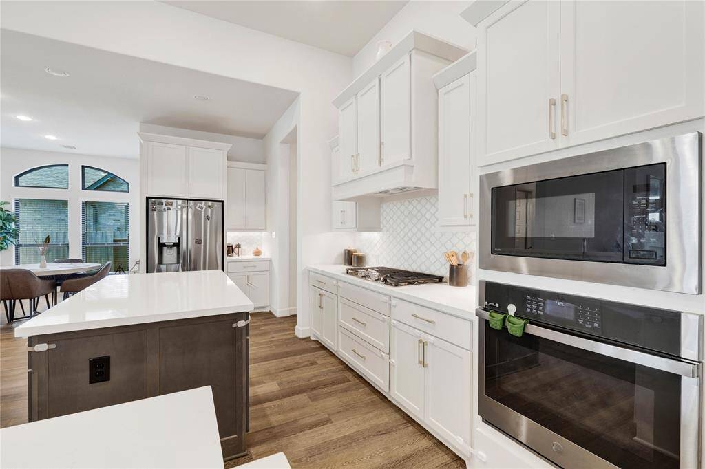 Stainless appliances, a 5-burner cook-top, and specious cabinets makes this kitchen very functional and luxurious.