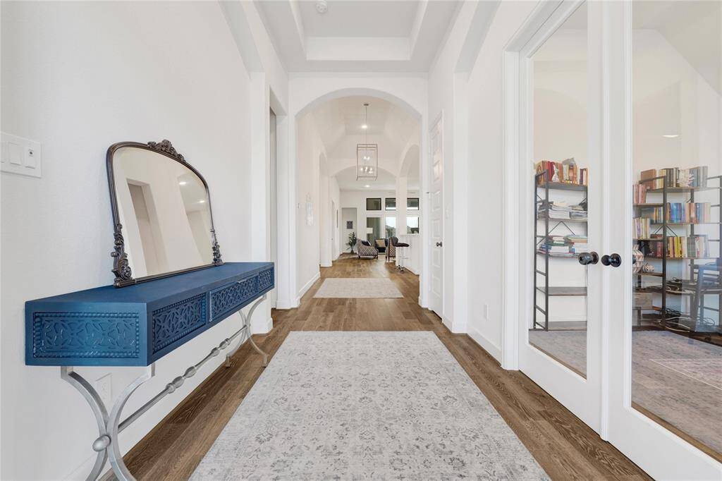 Foyer area with a french-door office on the right, bedrooms on the left, and leading to the main living area.