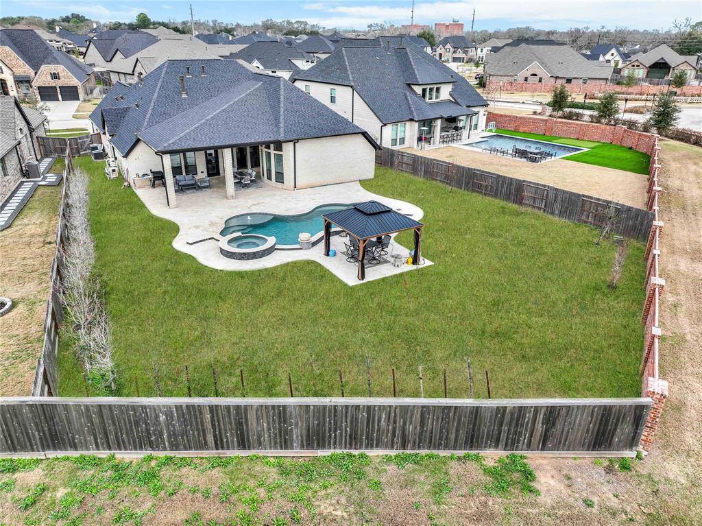 The expansive, oasis-style backyard boasts a luxury custom-built pool with a hot tub, all elegantly surrounded by a travertine patio. A charming gazebo offers the perfect retreat for relaxation and outdoor enjoyment.