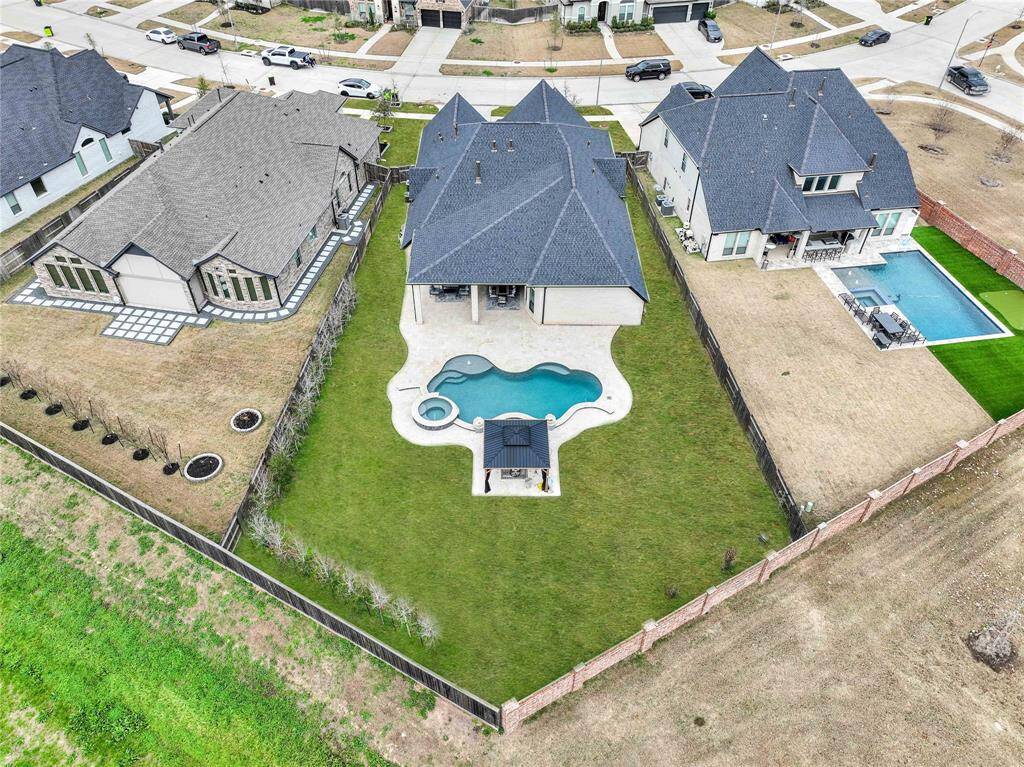 The expansive, oasis-style backyard boasts a luxury custom-built pool with a hot tub, all elegantly surrounded by a travertine patio. A charming gazebo offers the perfect retreat for relaxation and outdoor enjoyment.