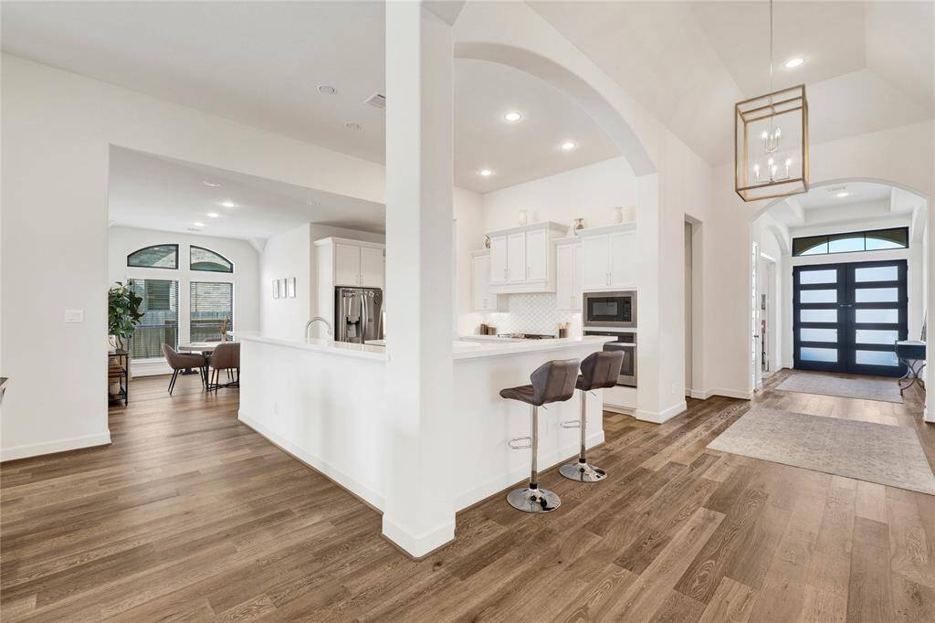 This open-concept kitchen is located at the heart of the house, seamlessly connects to the dining area, breakfast area, and the living room.
