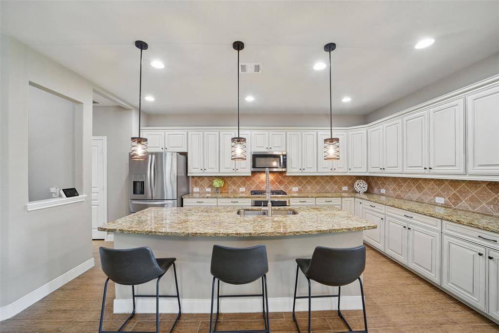 Look at this functional kitchen! Tons of cabinets, counter space, and island with sink!