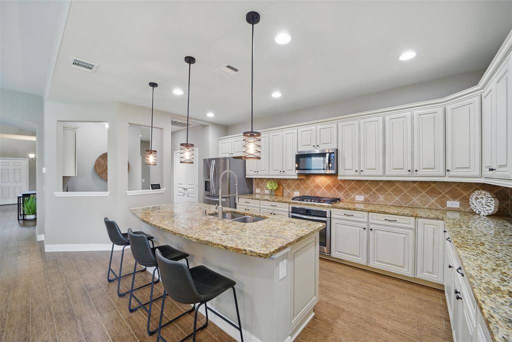 Pendant lighting over the island, undercabinet lighting, and can lights.