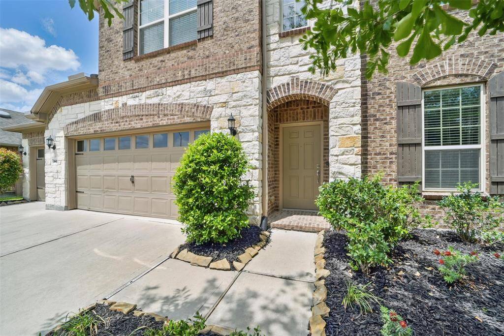 Brick and stone facade with mature landscaping.