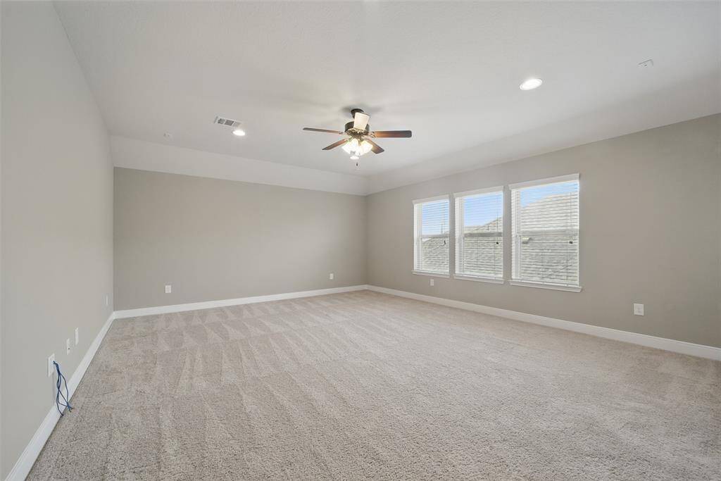 another view of the game room with can lighting and ceiling fan.