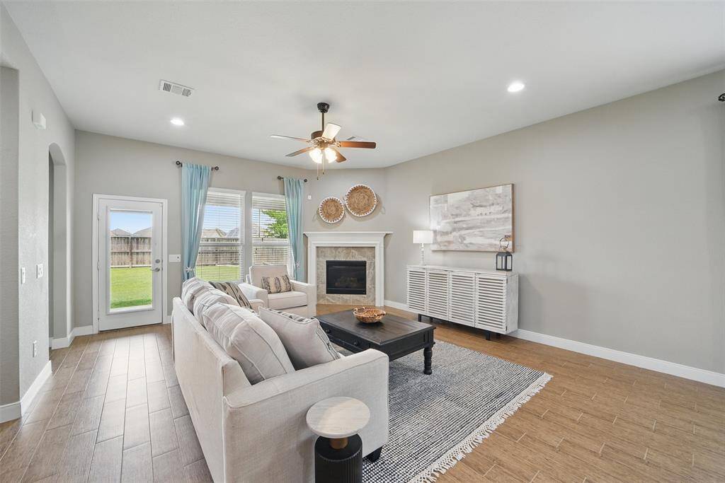 The living room has a corner gas fireplace, ceiling fan, and can host a large entertainment center/TV.