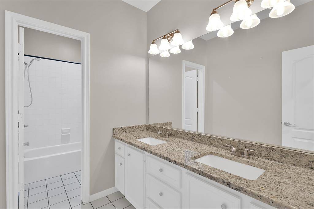 Large double sink, tub-shower secondary bathroom.