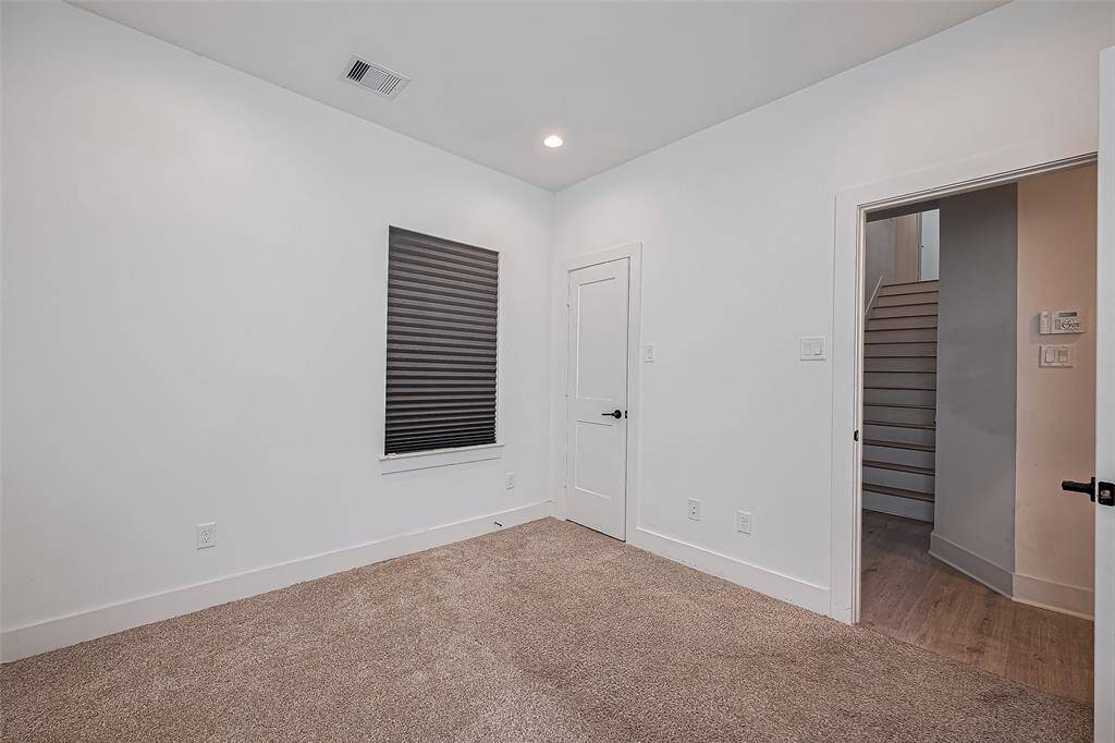 This private downstairs bedroom offers cozy comfort with plush carpet, recessed lighting, and easy access to the main level—ideal for guests, a home office, or a peaceful retreat.