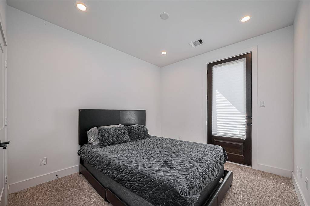 This third bedroom offers plush carpeting, recessed lighting, and a private patio door—creating a cozy yet functional retreat for rest and relaxation.