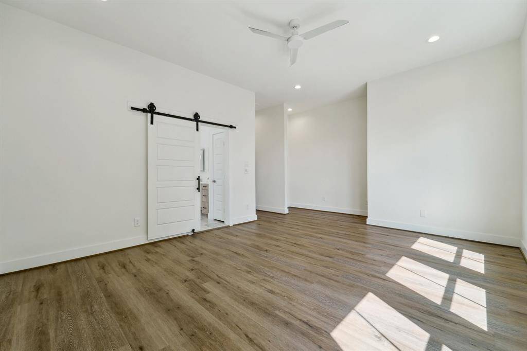 Barn door leading to primary bathroom