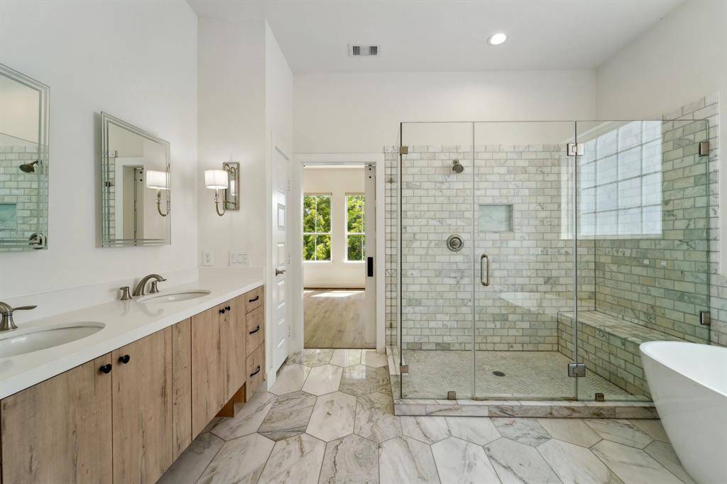 Absolutely stunning bathroom with marble floors and quartz countertops. Walk in shower enclosed in frameless glass..