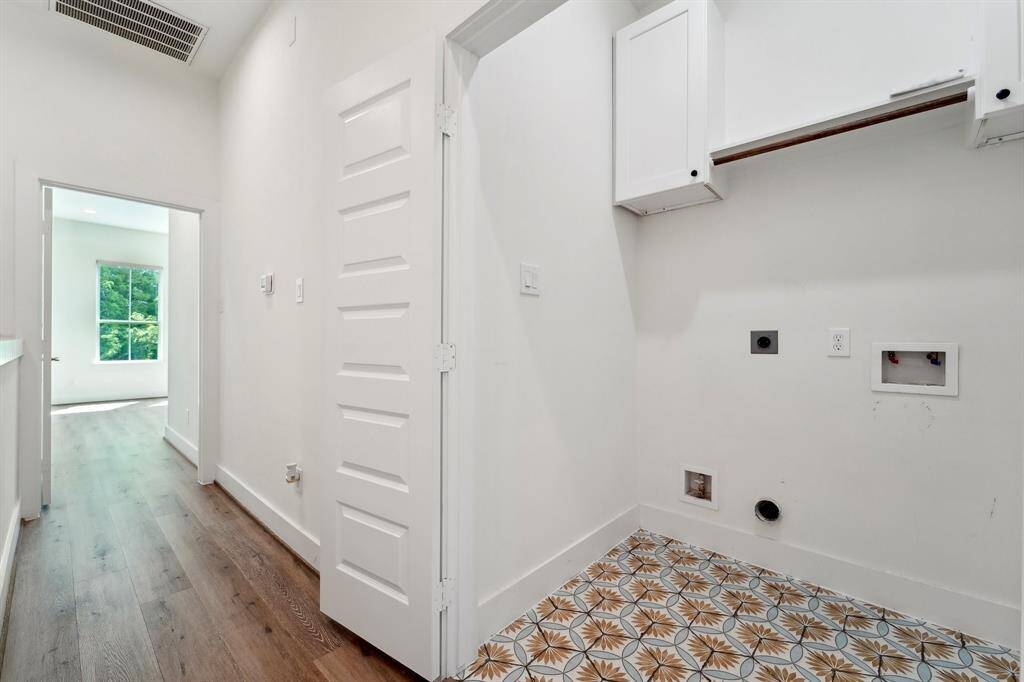 Laundry room between the 3rd bedroom and primary suite